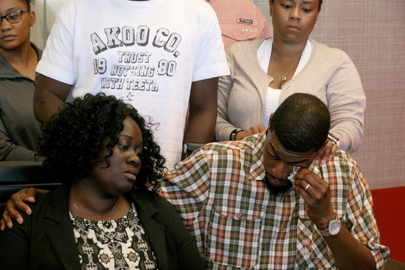 Odell Edwards wipes away tears as he sits with his wife, Charmaine Edwards, listenintg to...