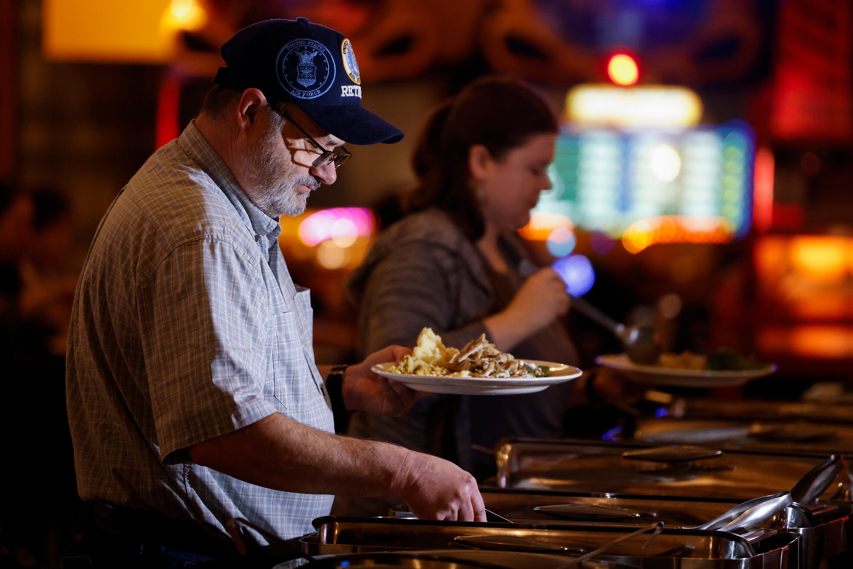 James Stratton, an Air Force veteran, gets in line to get the Thanksgiving meal alongside...