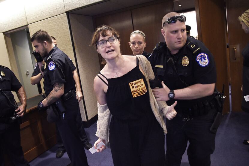 A protester is escorted outside of the Brett Kavanaugh confirmation hearing Friday in...