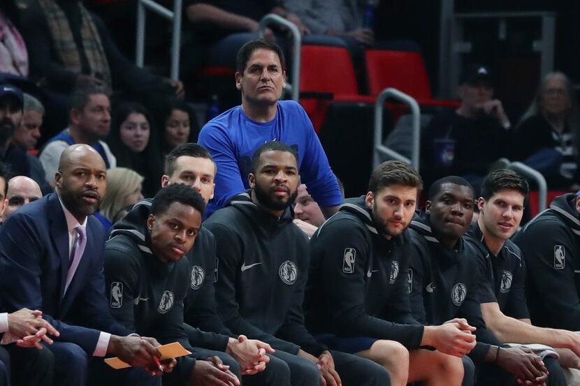 Dallas Mavericks owner Mark Cuban, sitting behind the bench, looks on during the first half...