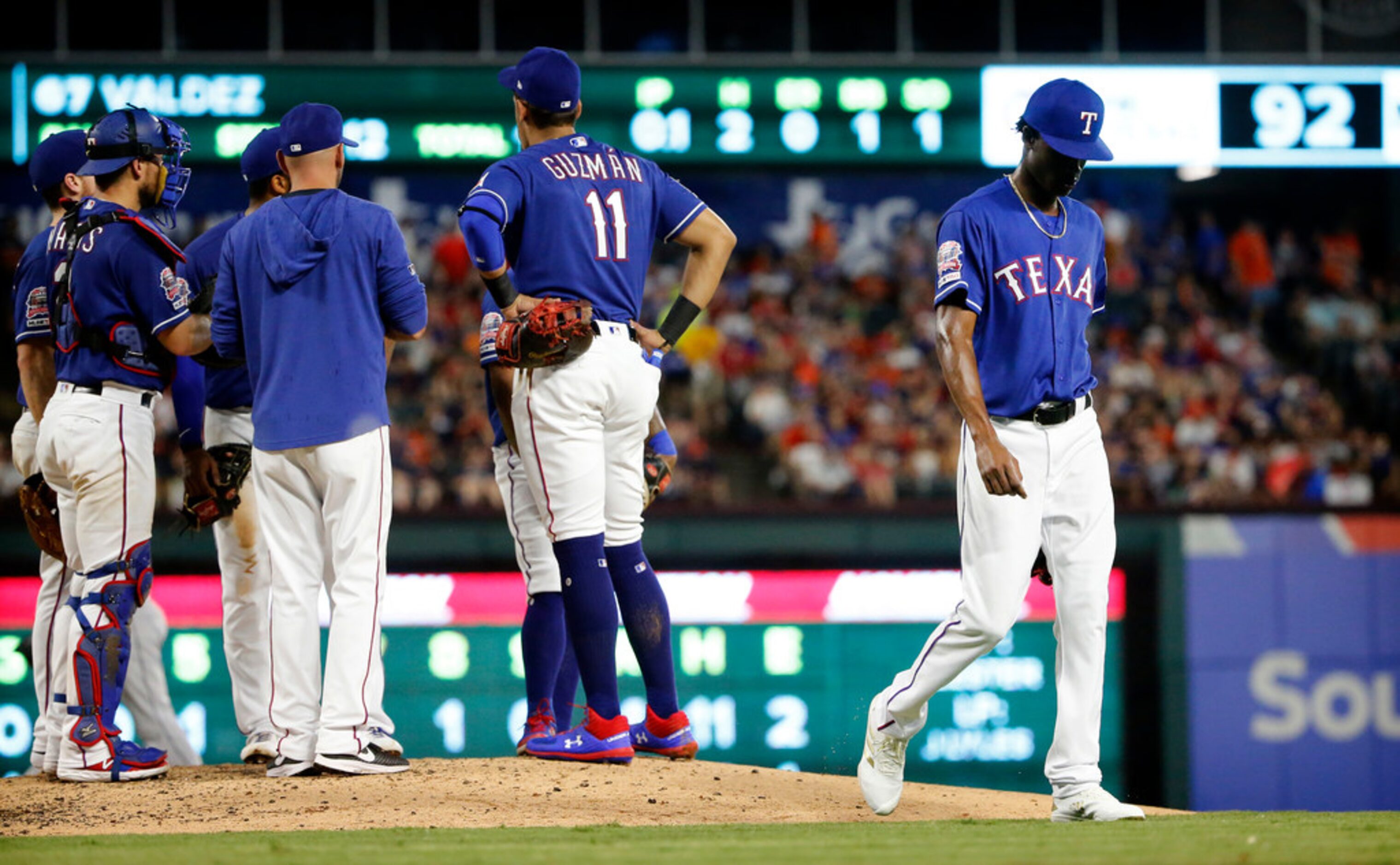 Texas Rangers relief pitcher Phillips Valdez (right) walks to the dugout after being pulled...