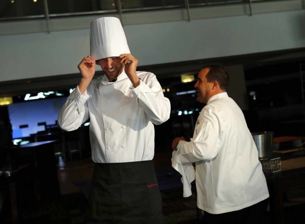 Dallas Mavericks forward (and chef) Dirk Nowitzki tries on his hat before he and American...