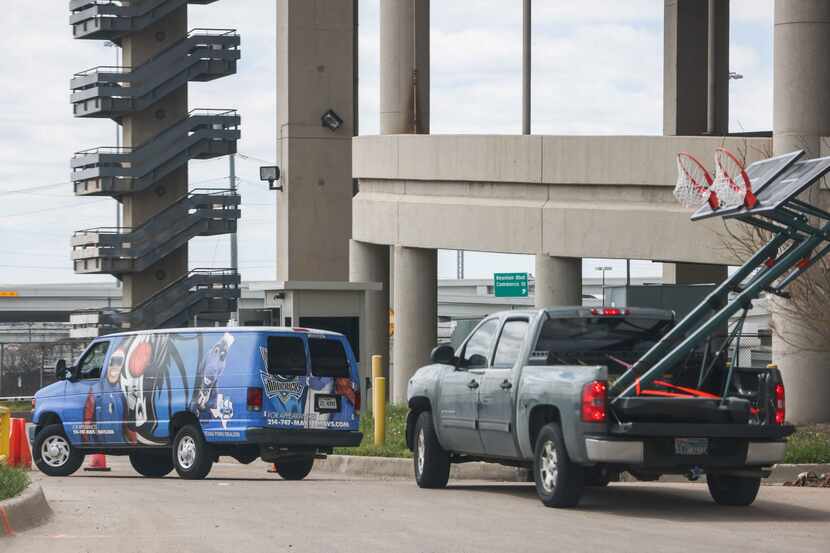 A van identified with NBA team Mavericks logo, arrives along with a pickup carrying two...