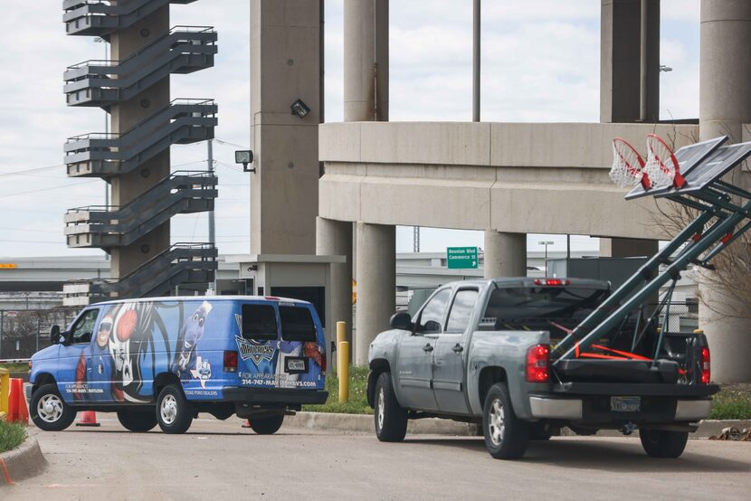 A van with the NBA team Mavericks logo, arrives along with a pickup carrying two basketball...