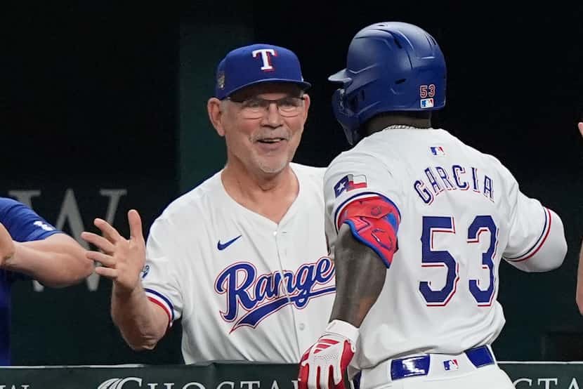 Texas Rangers manager Bruce Bochy, left, congratulates Adolis García (53) after he hit a...