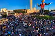 Large crowds fill Big Tex Circle, buying coupons and purchasing food from vendors while...