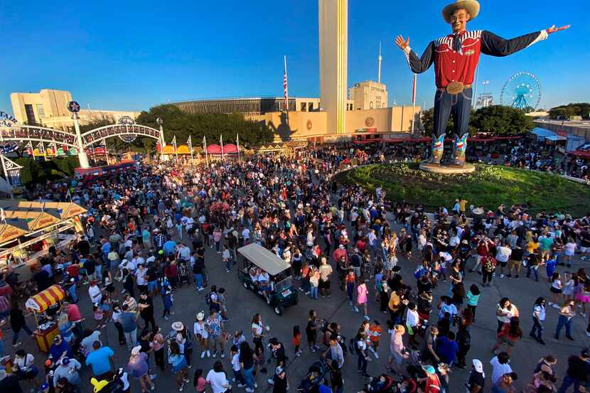 Large crowds fill Big Tex Circle, buying coupons and purchasing food from vendors while...