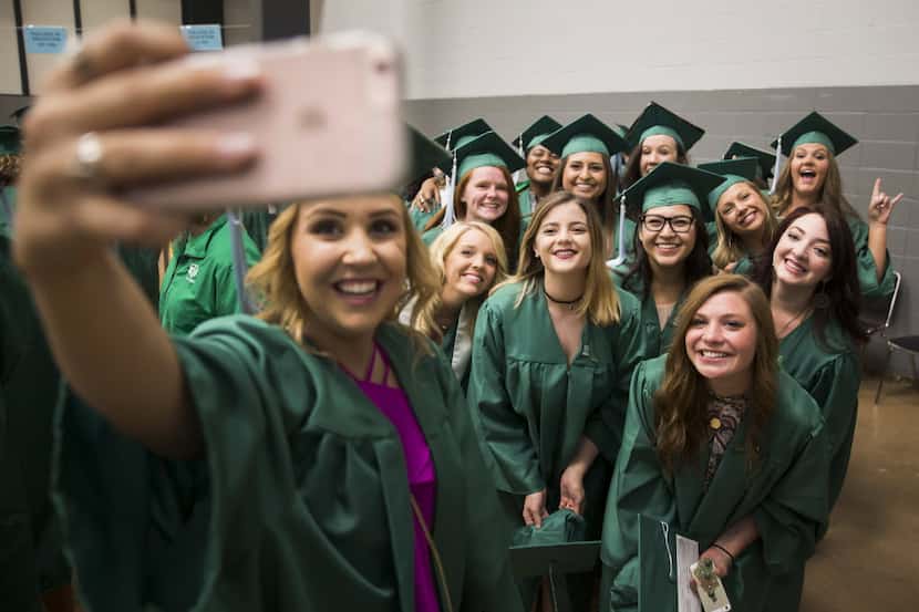 Katelynn Blasavage (center) poses for a selfie with fellow UNT graduates before they process...