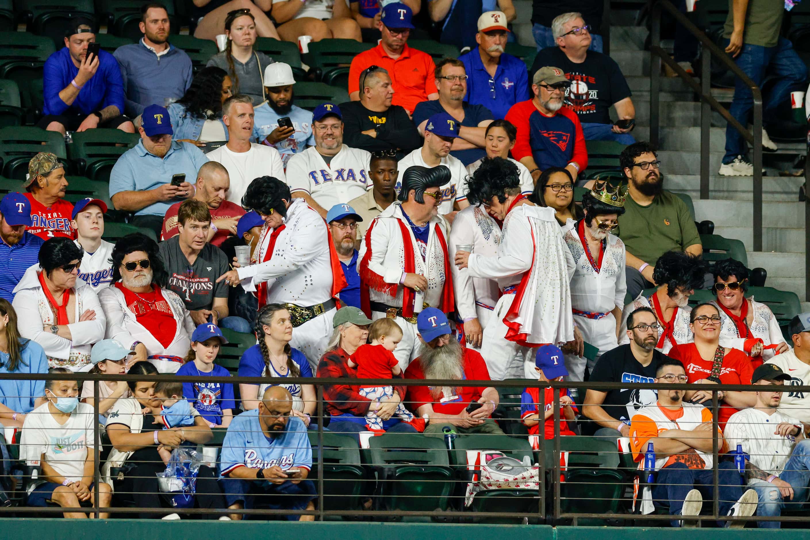A group of fans dressed as Elvis Presley take their seats during the eighth inning of a game...