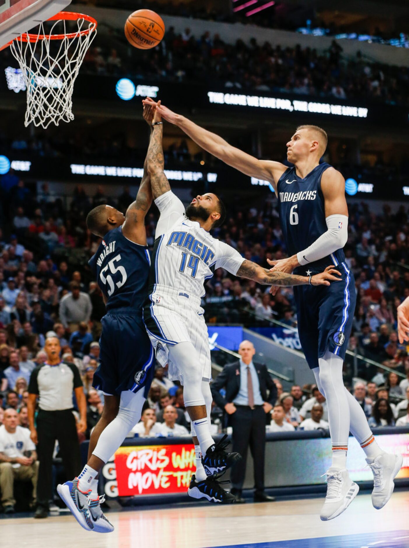 Dallas Mavericks guard Delon Wright (55) and forward Kristaps Porzingis (6) block a shot by...