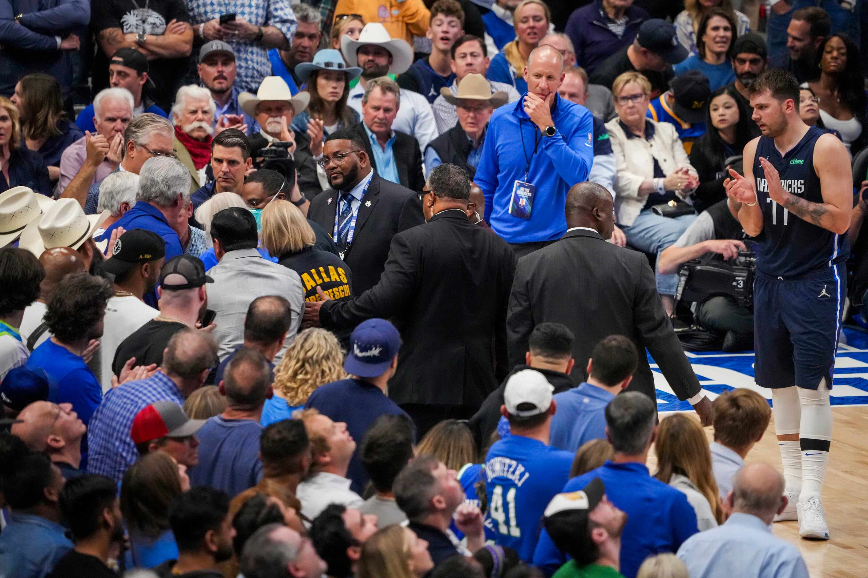 Dallas Mavericks guard Luka Doncic applauds as Dallas Fire Rescue personnel assist a...