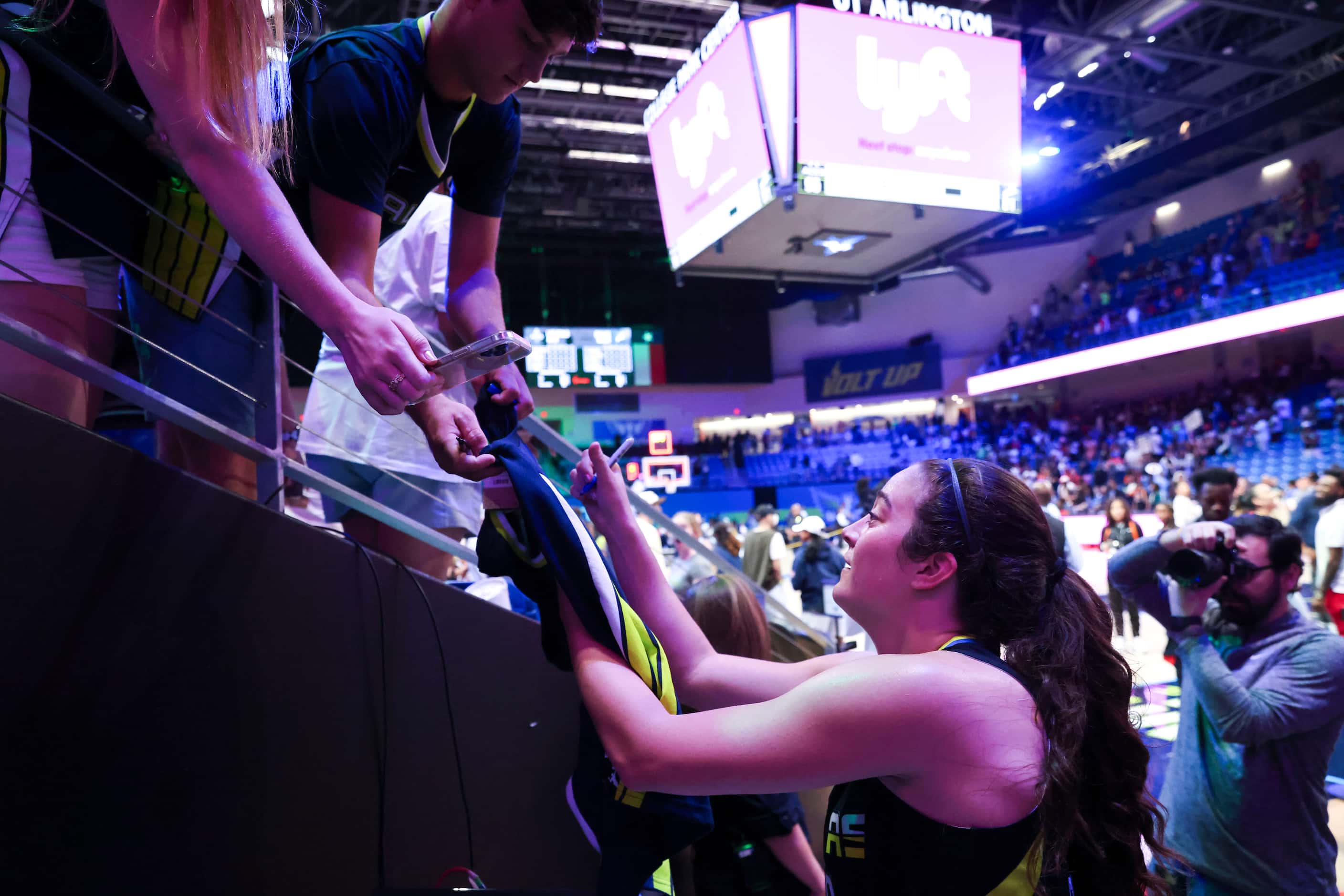 Dallas Wings forward Maddy Siegrist gives autographs to fans following a WNBA basketball...
