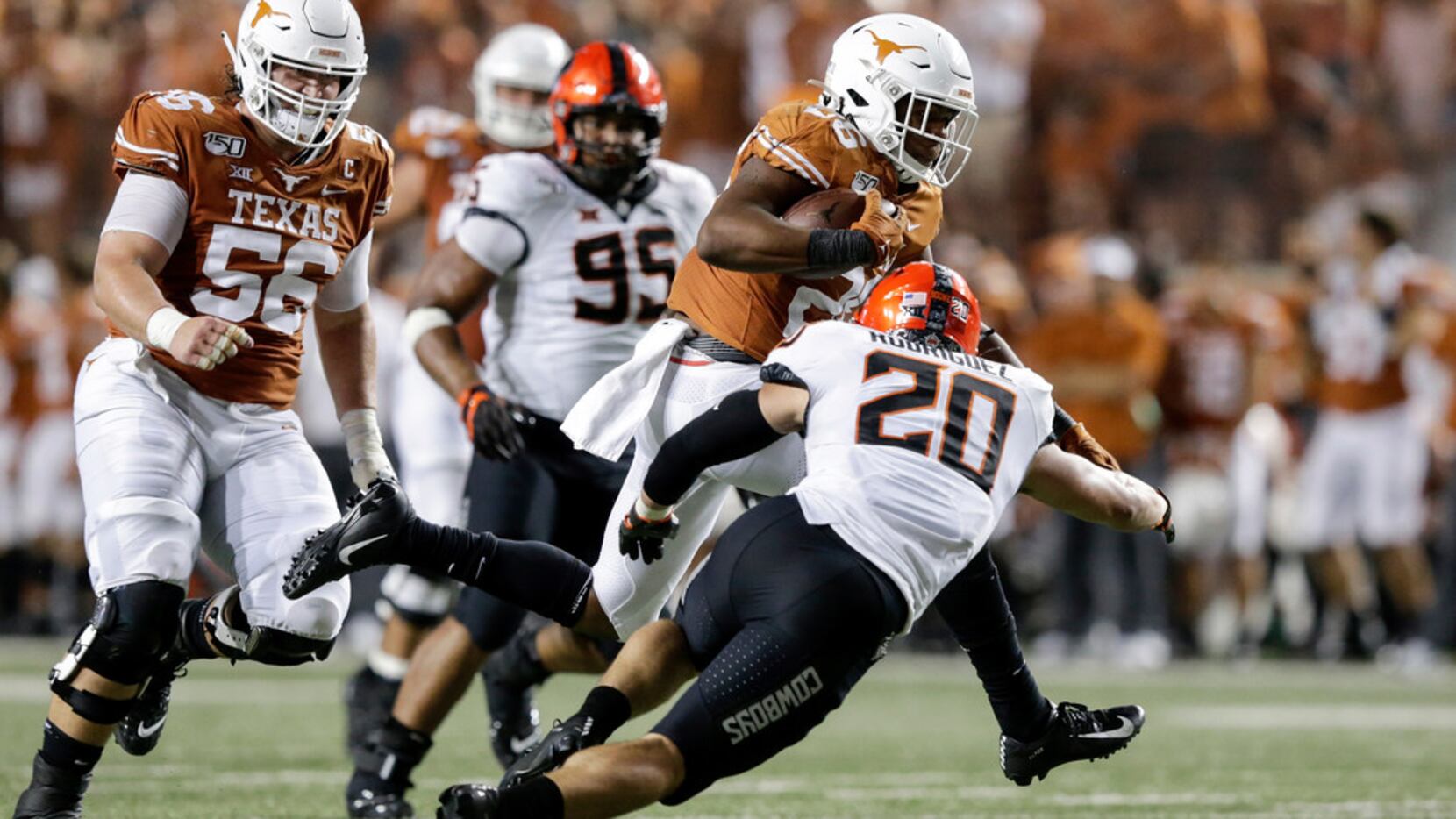Keaontay Ingram #26 of the Texas Longhorns runs the ball in the fourth quarter defended by...