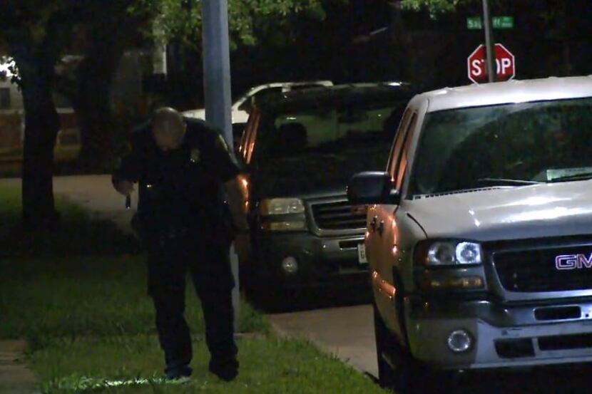 A Houston police officer looks for evidence after a home invasion Friday morning in the...