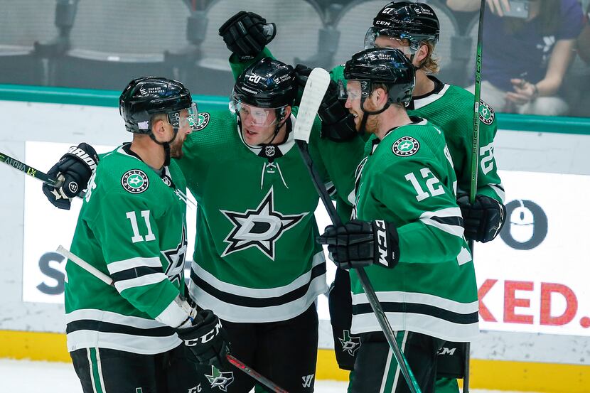 Dallas Stars defenseman Ryan Suter, second from left, is congratulated by teammates after...