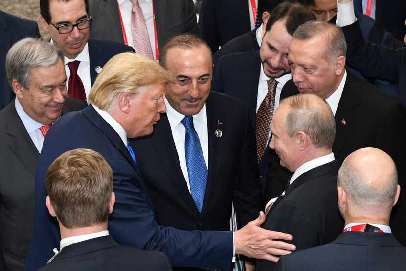 President Donald Trump (center left) talks with Russian President Vladimir Putin (center...