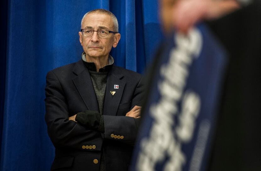 Campaign Chair John Podesta listens backstage to former Secretary of State Hillary Clinton...
