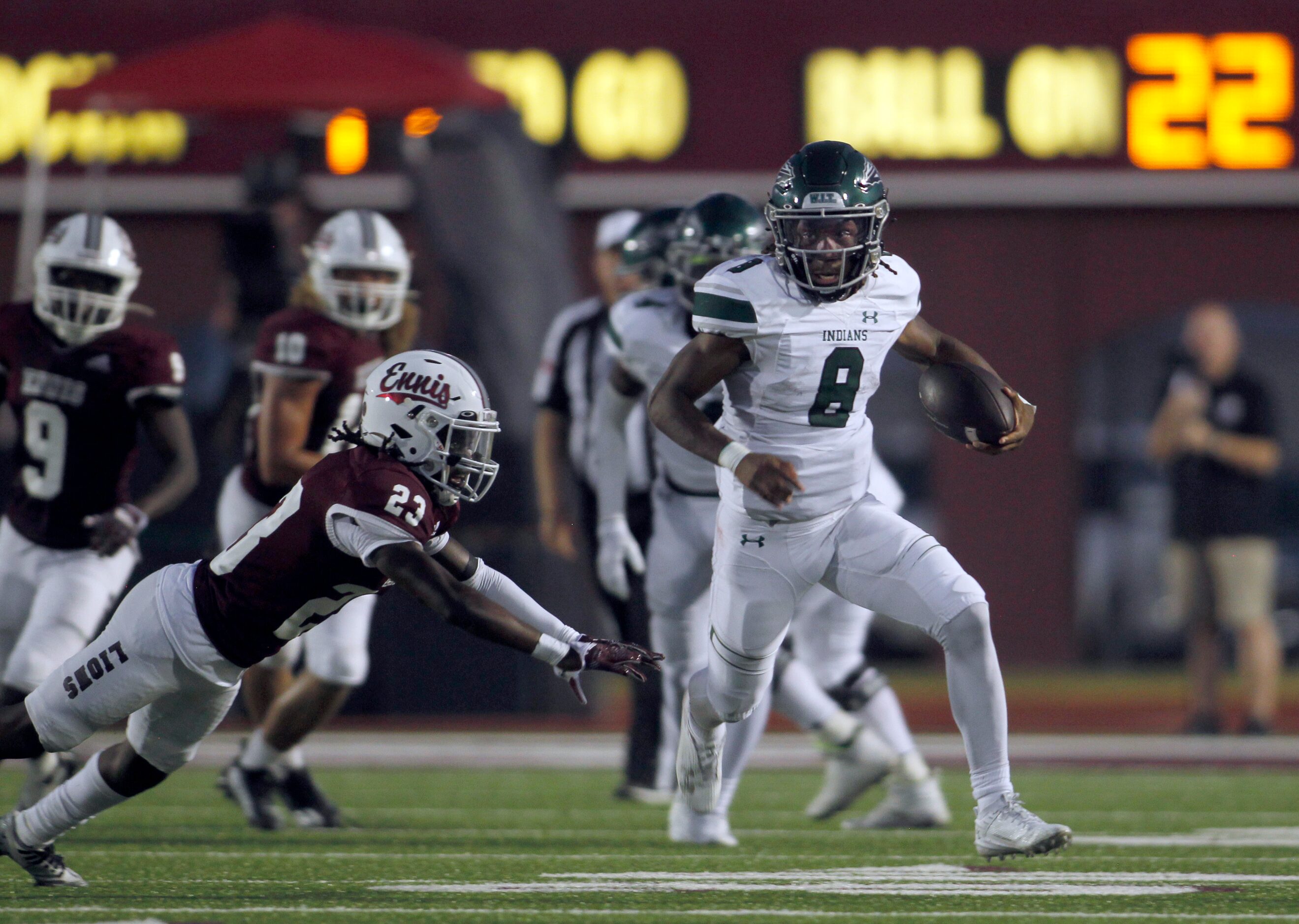 Waxahachie quarterback Ramon McKinney Jr. (8) sprints out of the grasp of Ennis defensive...