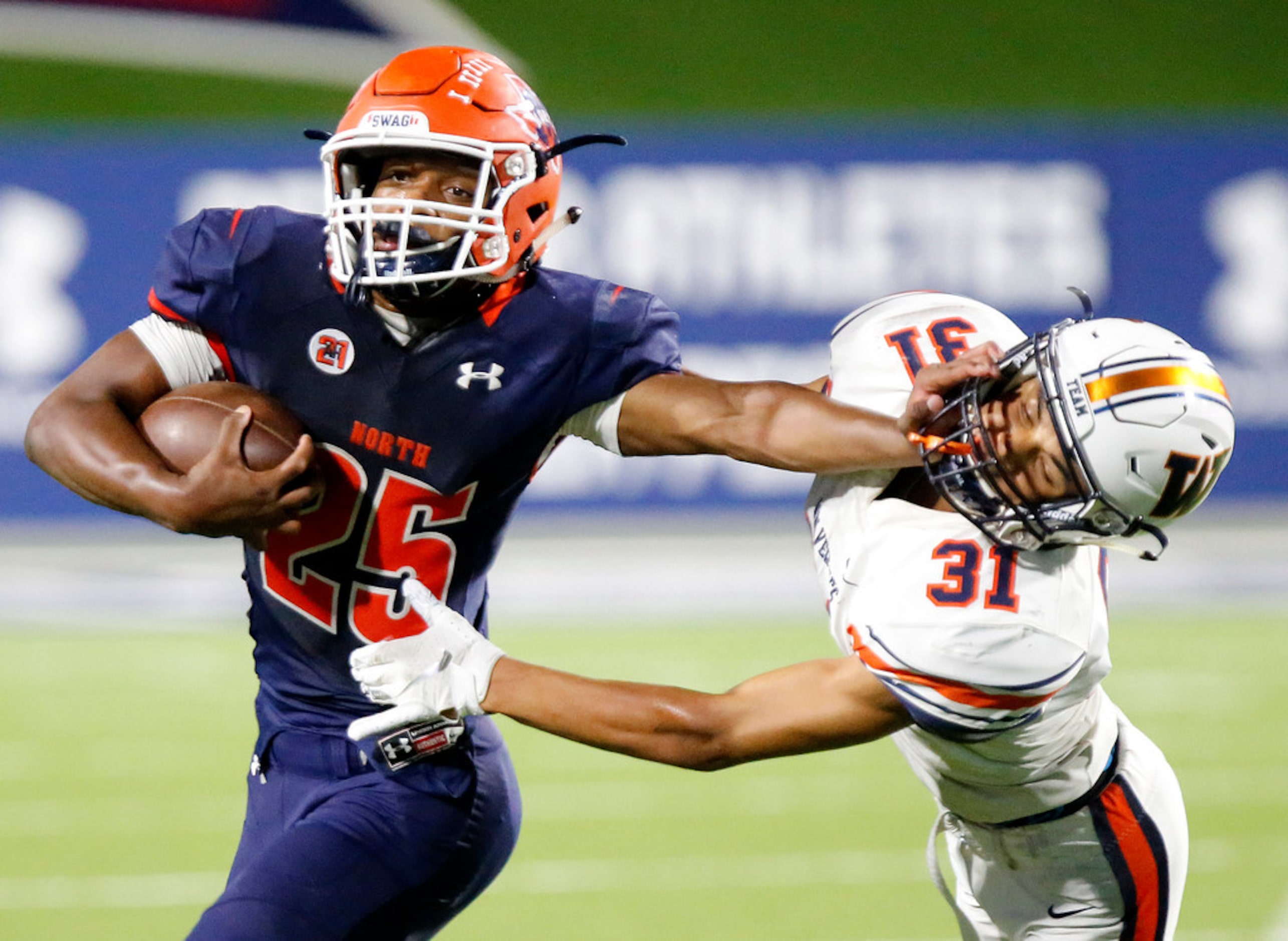 McKinney North High School running back Jayden Smith (25) stiff arms Wakeland High School...