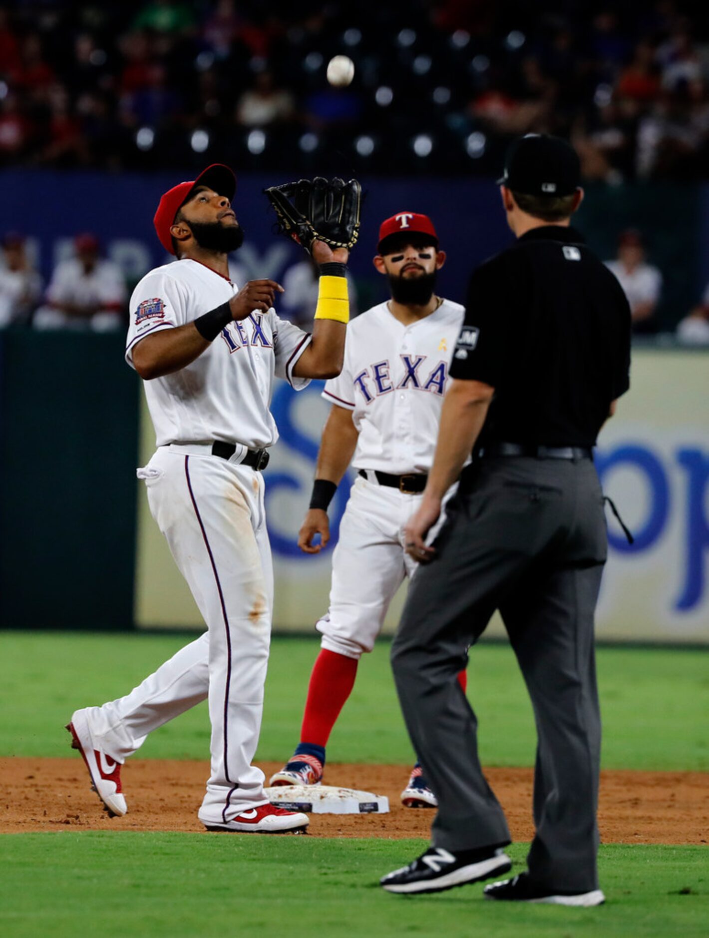 Texas Rangers' Elvis Andrus reaches up for pop out by Oakland Athletics' Jurickson Profar as...