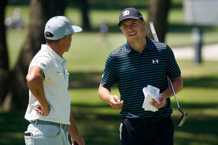 PGA Tour golfer Jordan Spieth visits with playing partner Rickie Fowler after putting on No....