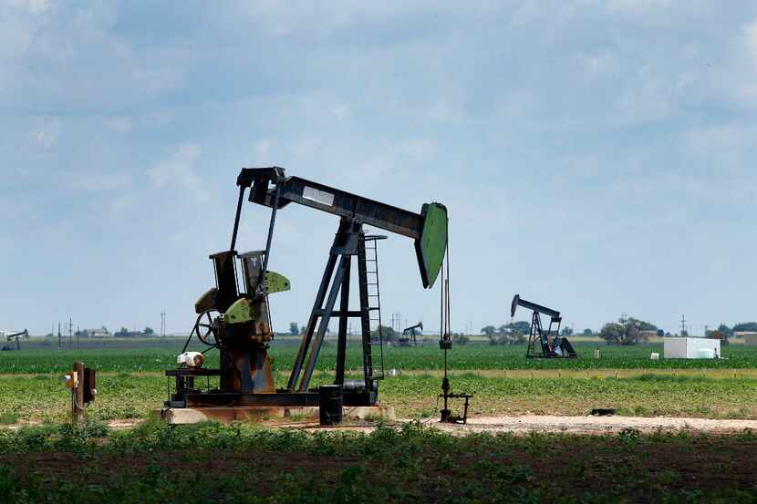 Pump jacks draw oil in cotton fields north of Lubbock. The SEC settled a complaint against a...