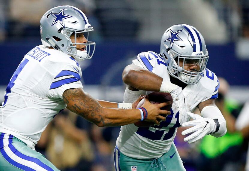 Dallas Cowboys quarterback Dak Prescott (4) fakes the handoff to running back Ezekiel...