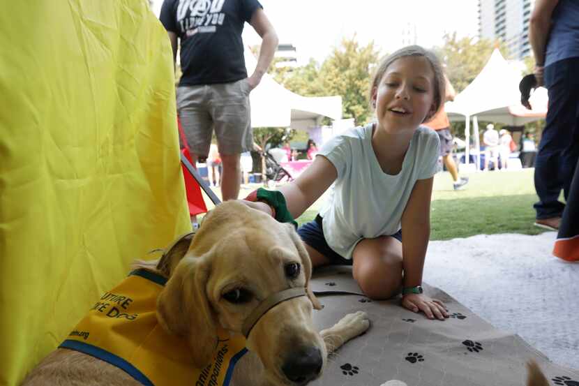 Kate Workman, 10, pets Polly of the nonprofit Canine Companions during Voly in the Park at...