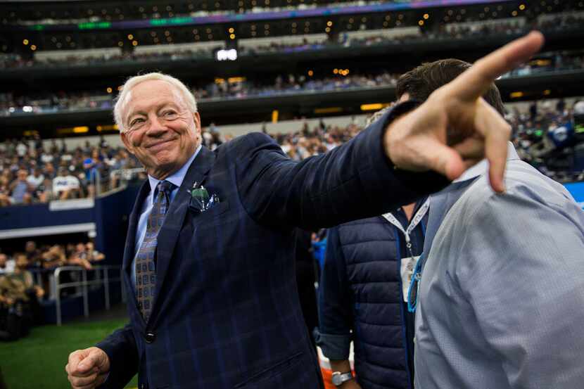 Dallas Cowboys owner Jerry Jones points to a friend on the sideline before an NFL football...