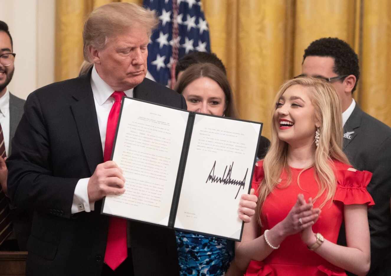 US President Donald Trump, alongside Justine Murray, a student at Syracuse University, after...