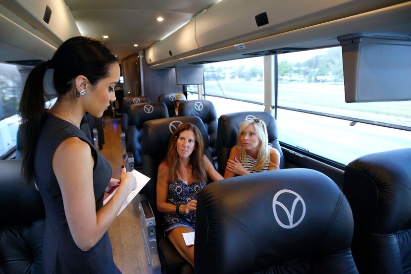 Sarah Moore, left, attendant for Vonlane, explains what guests can order before their bus...