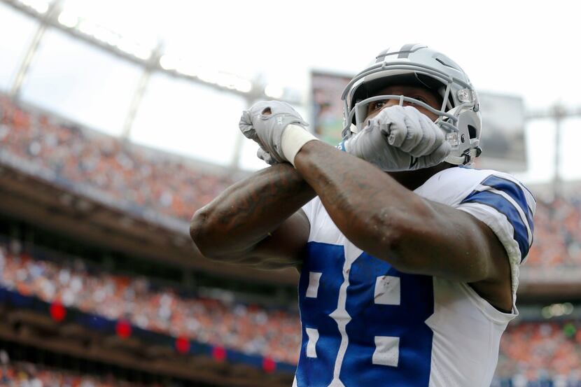 Dallas Cowboys wide receiver Dez Bryant (88) throws up the "X," after scoring a touchdown in...