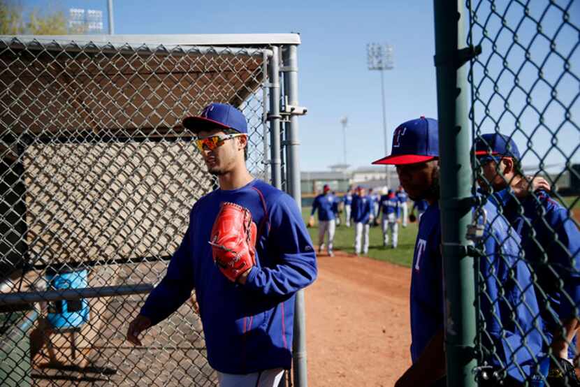  Texas Rangers pitcher Yu Darvish walks out to a field to stretch during a workout at the...