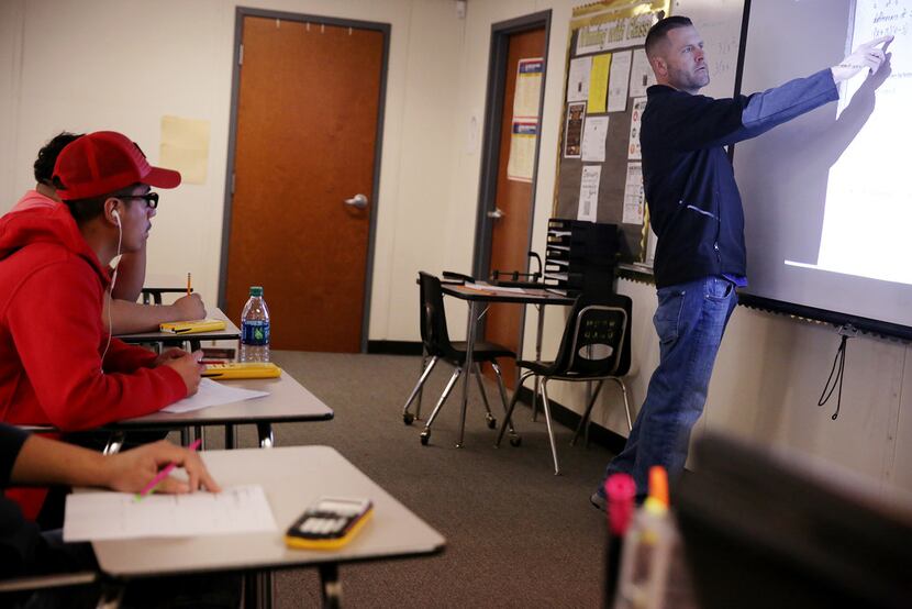 Plano East High School mathematics teacher Gary Don Moore speaks to students with fellow...