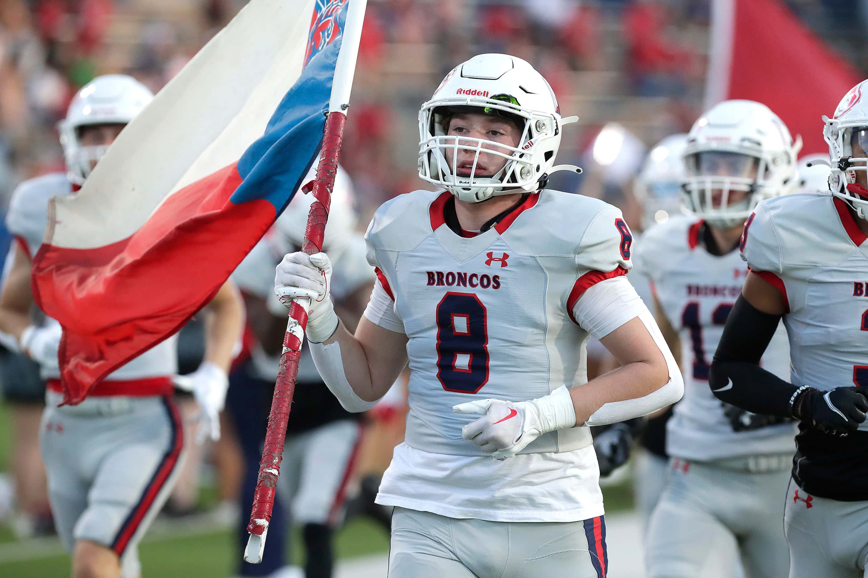 McKinney Boyd High School tight end Carson Denning (8) carries a flag onto the field before...