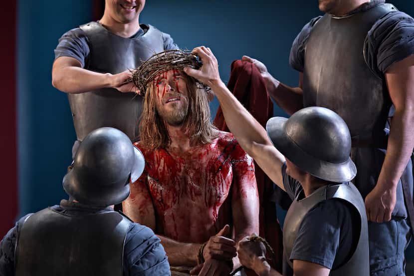 Roman soldiers place the crown of thorns on Jesus' head in the Passion Play in the German...