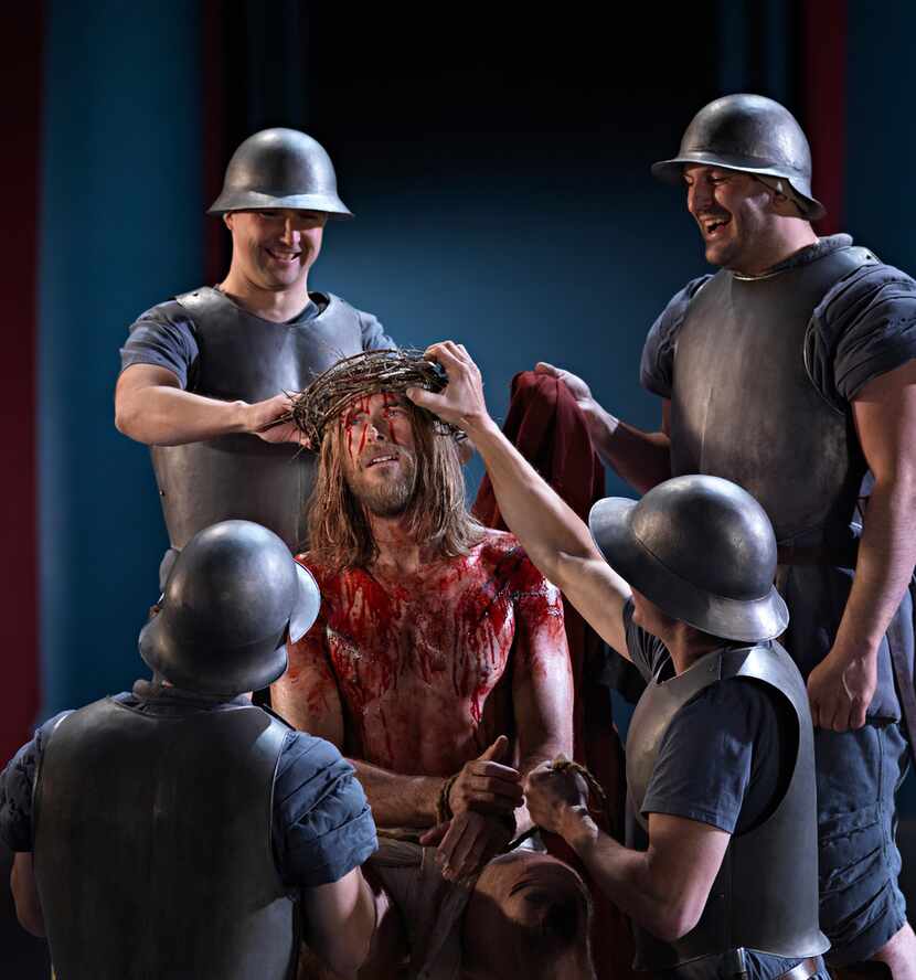 Roman soldiers place the crown of thorns on Jesus' head in the Passion Play in the German...