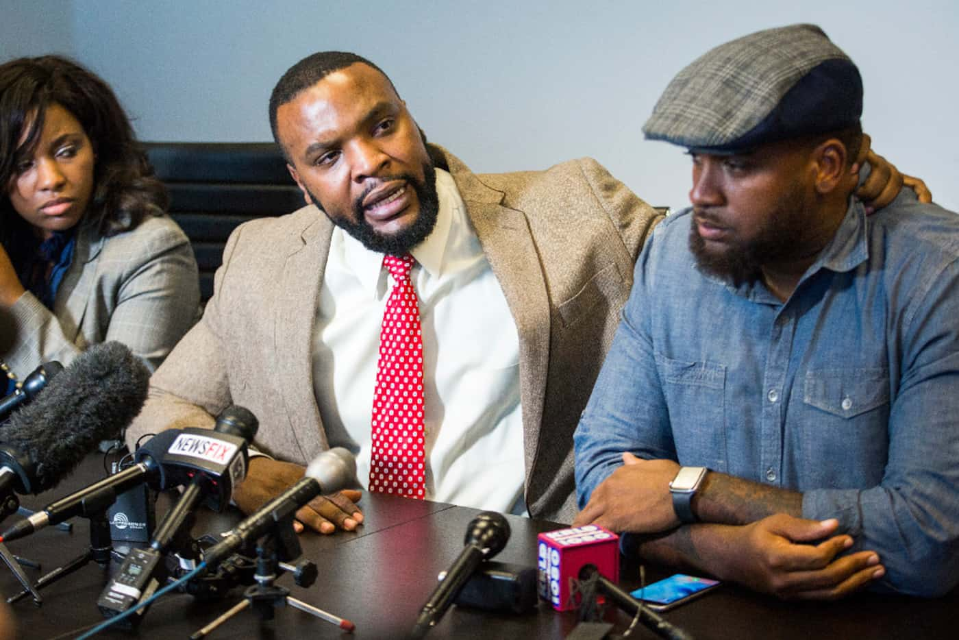 Attorney Lee Merritt (center), who represents Jacqueline Craig, grabs activist Cory Hughes...