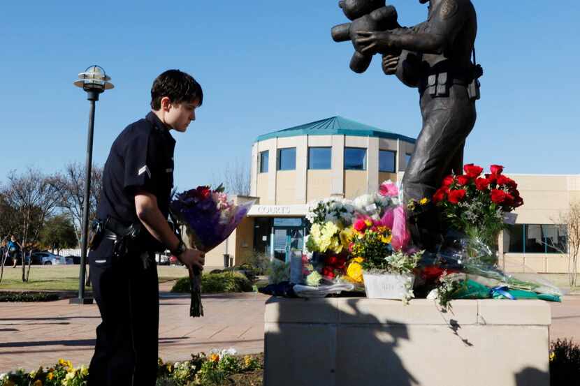  Officer M. Cordova of the Dallas Police Department placed flowers in memory of fallen...