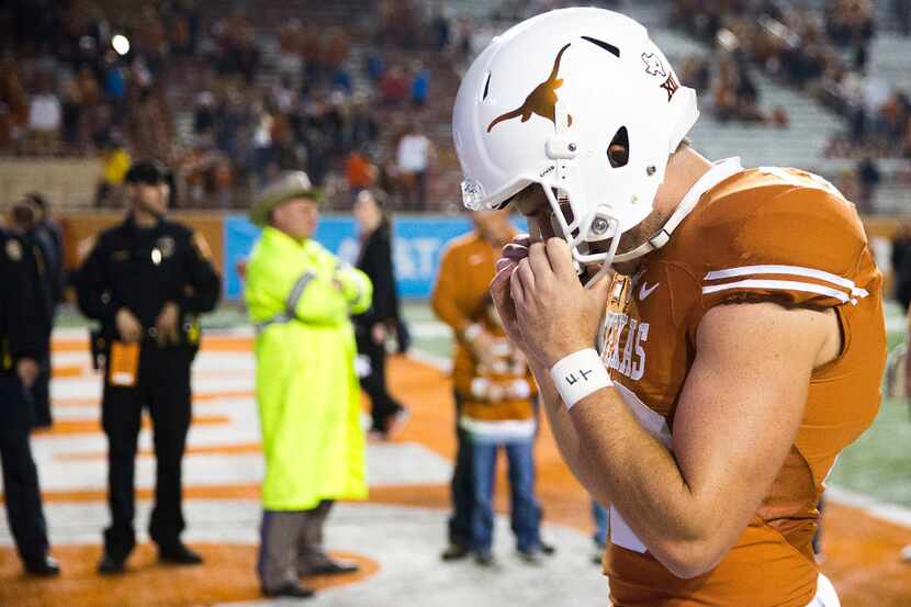 Texas punter Michael Dickson clutches his facemask as he walks off the field after a loss to...
