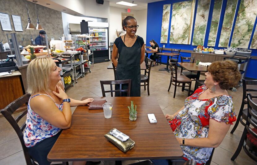 Fana Yohannes, center, talks with her friends Angela Dennison, left, and Beth Basile, who...