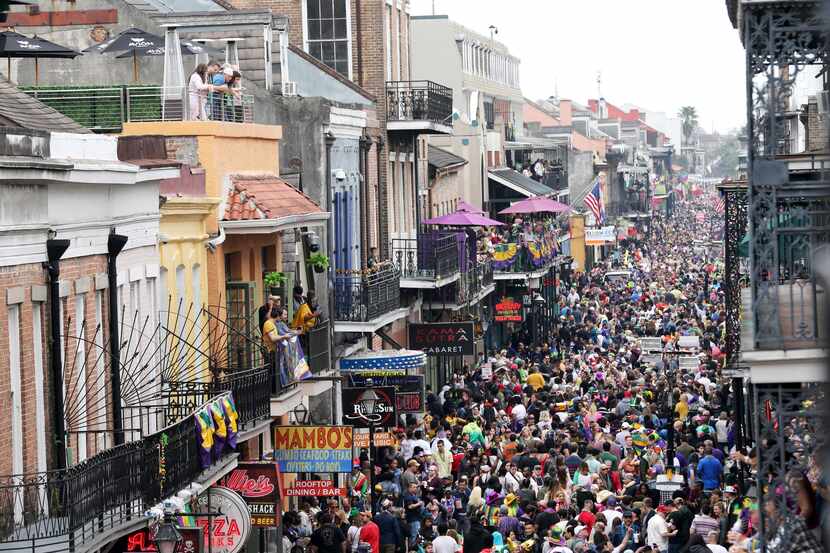 Un grupo de personas caminan por Bourbon Street para la celebración de carnaval de Nueva...