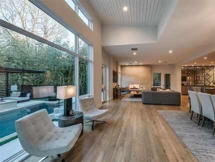Living and dining areas with large windows looking out at trees and the pool