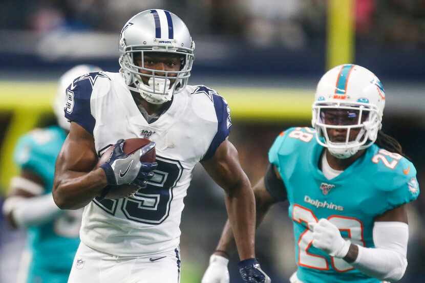 Dallas Cowboys wide receiver Amari Cooper (19) carries the ball past Miami Dolphins strong...