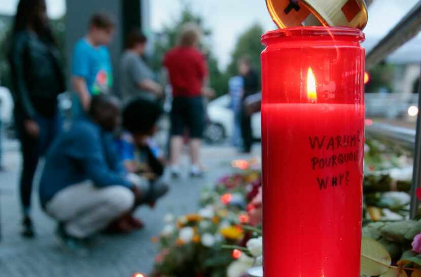 'Why?' is written in three languages on a candle outside the Munich shopping mall where a...