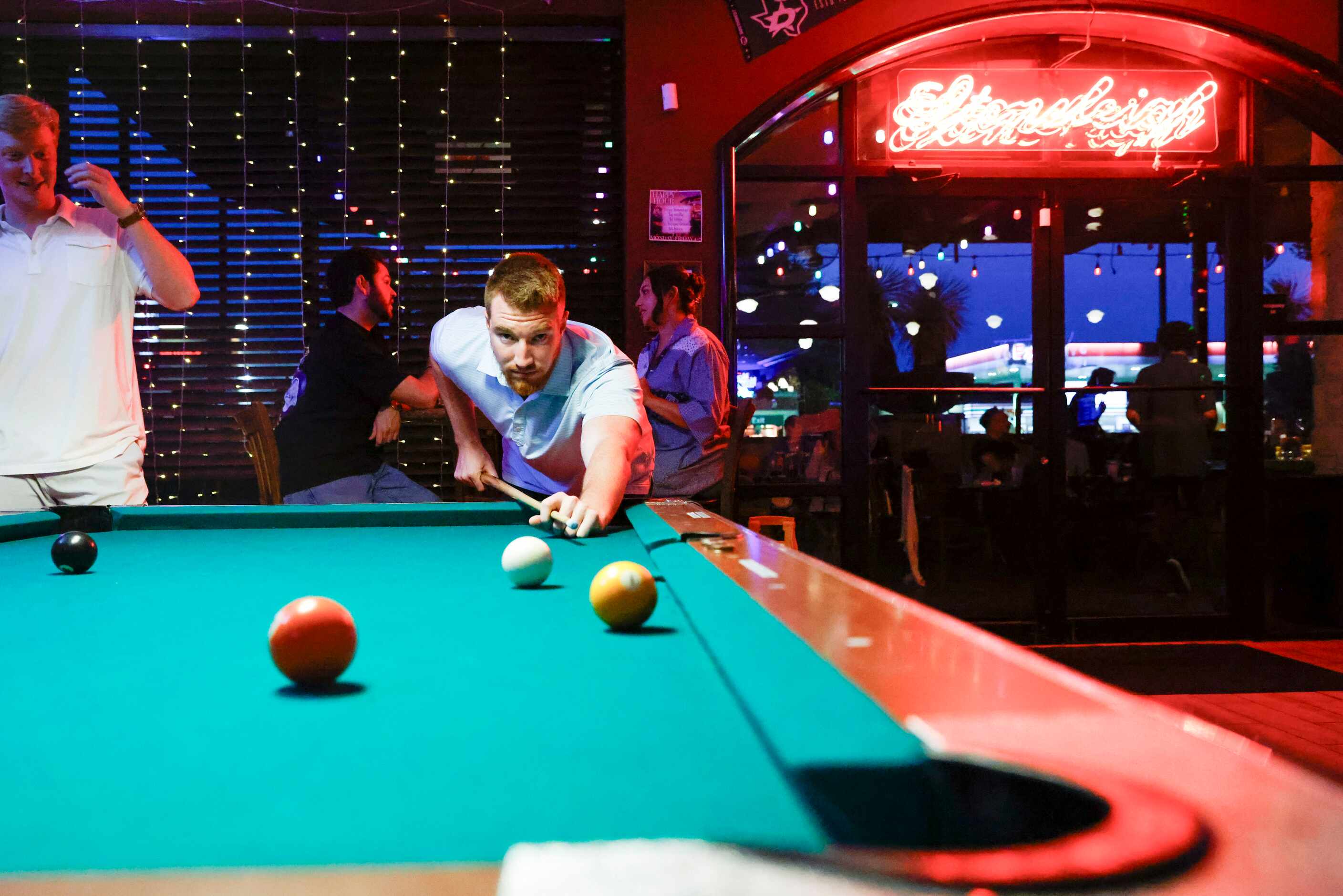 Customer Grant Dougherty plays pool at the relocated Stoneleigh P in Dallas. 
