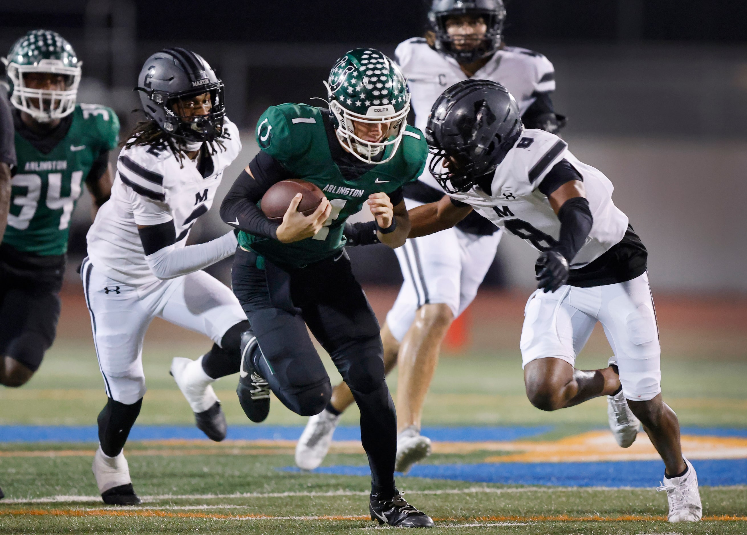 Arlington High quarterback Coleman Cravens (1) carries the ball before being tackled by...