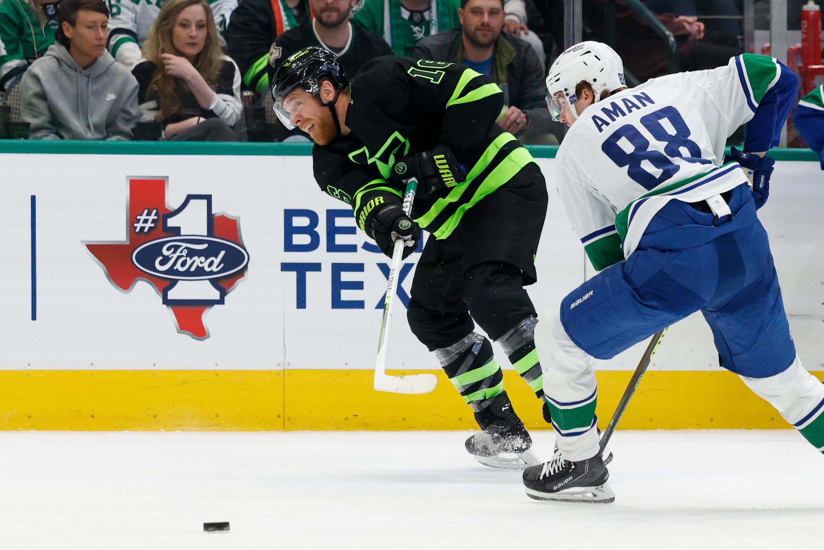 Dallas Stars center Max Domi (18) passes the puck up the ice ahead of Vancouver Canucks...