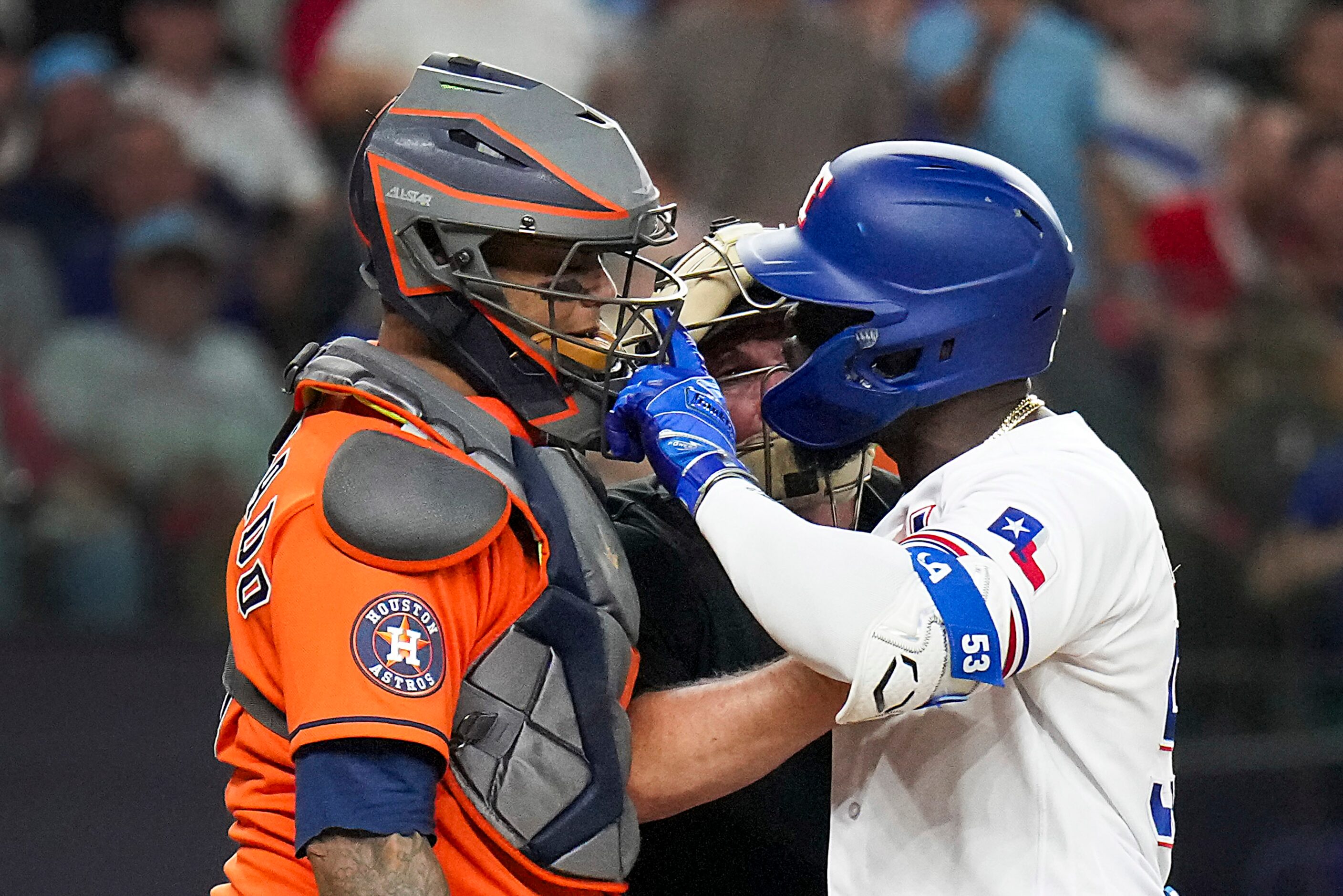 Umpire Marvin Hudson (51) tries to separate Texas Rangers right fielder Adolis Garcia (53)...