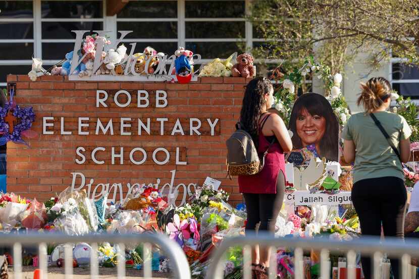 People visit a memorial outside of Robb Elementary School shooting in Uvalde, Texas, Sunday,...